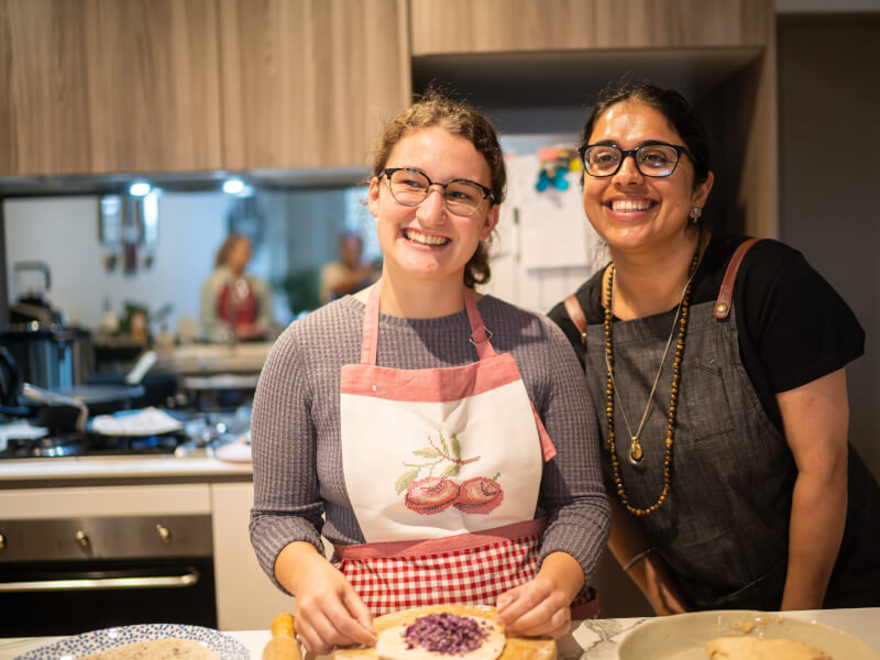 Two women smiling in a cooking class
